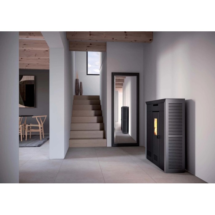 Stufa a pellet t.b.t. nera in un moderno spazio abitativo con scale e specchio.