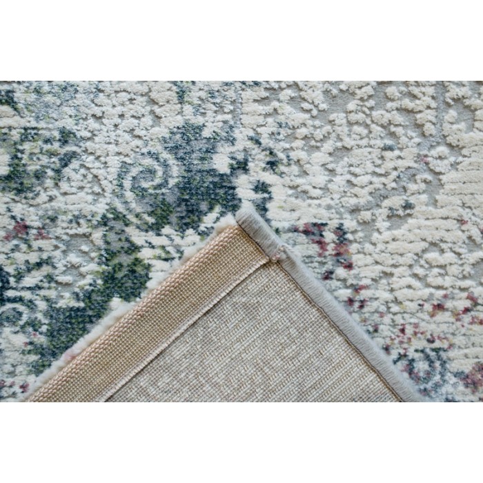 Tappeto moderno con motivo floreale nei toni del verde, beige e rosa.