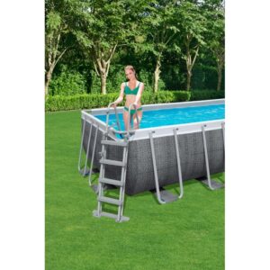 Piscina fuori terra rigida rettangolare t.b.t. con scaletta in giardino, donna entra in acqua.