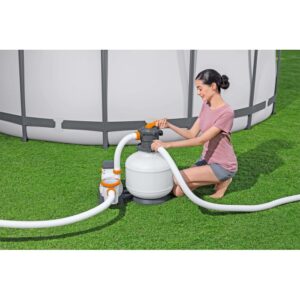 Donna che utilizza filtro a sabbia per piscina. Sistema di filtraggio con piscina in giardino.