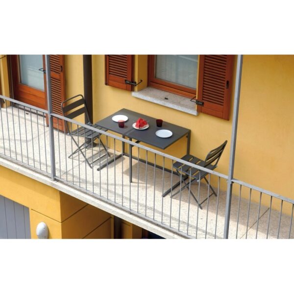 Set di mobili da balcone grigio con tavolo e due sedie su un balcone.