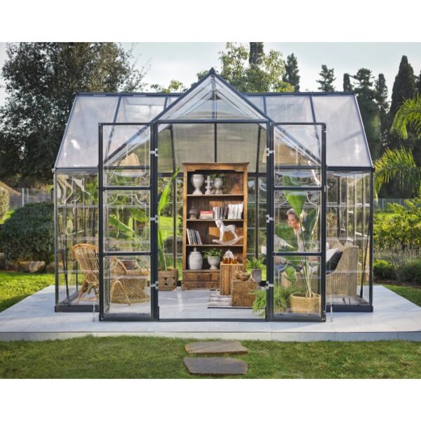 Serra Palram Canopia Victory Orangerie con libreria e piante in giardino.