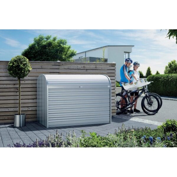 Box da giardino Biohort StoreMax 160 in argento metallizzato con serranda e due biciclette accanto.