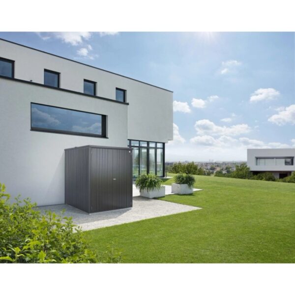 Armadio da esterno Biohort Large, grigio scuro metallizzato, davanti a casa moderna su prato.