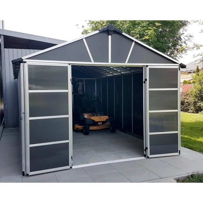 Casetta da giardino in metallo Palram Yukon, 17,2 m², antracite con porte scorrevoli aperte e tosaerba all'interno.