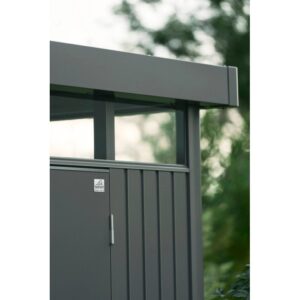 Dettaglio della casetta attrezzi in metallo Biohort HighLine grigio quarzo metallizzato. Parete, finestra, porta e tetto piatto.