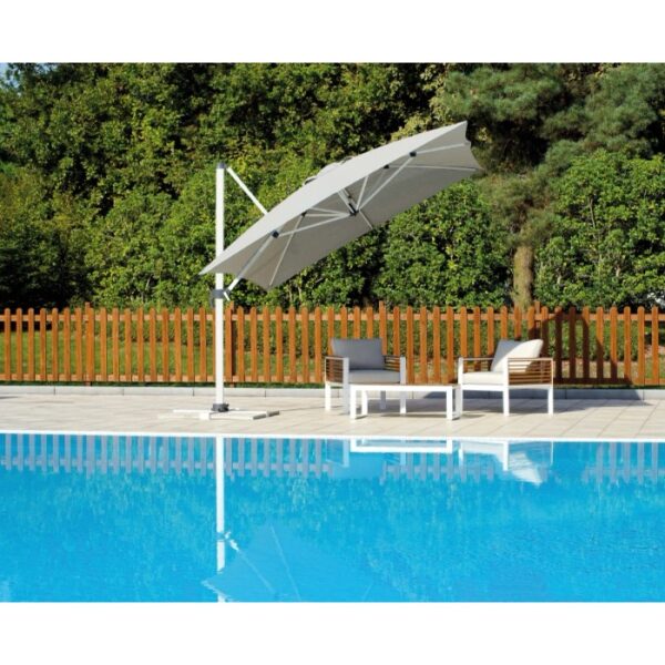 Ombrellone a braccio t.b.t. grigio accanto a piscina e mobili da giardino.