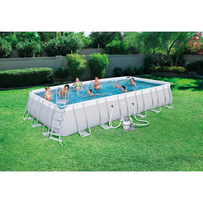 Piscina rettangolare con struttura in acciaio, scaletta e pompa filtro in giardino.