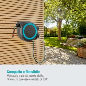 Avvolgitubo a parete con tubo flessibile su facciata in legno in giardino.
