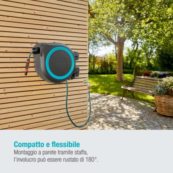 Avvolgitubo a parete con tubo flessibile su facciata in legno in giardino.