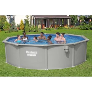 Otto persone nella piscina Bestway Hydrium in giardino. Piscina con pareti in acciaio per il divertimento estivo.