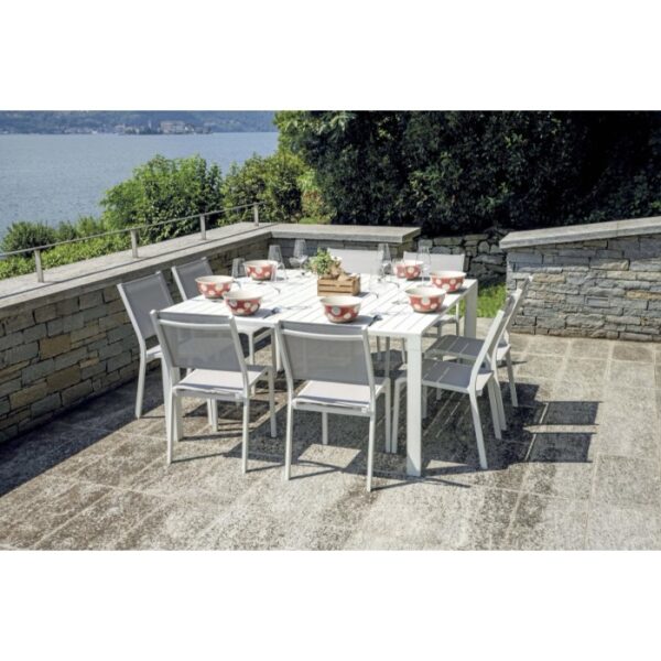 Tavolo da giardino bianco con sedie, apparecchiato con ciotole. Ideale per mangiare all'aperto.