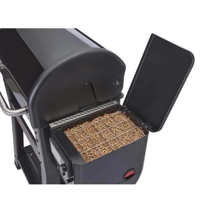 Dettaglio del barbecue a pellet Weber Searwood con serbatoio pellet aperto, riempito con pellet di legno.