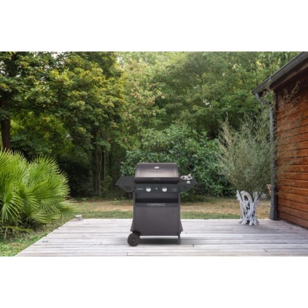 Barbecue a gas nero t.b.t. con ripiani laterali su un patio in legno in giardino.