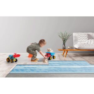 Bambino gioca con macchinine e costruzioni su una t.b.t. blu.