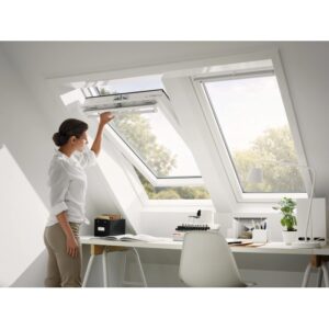 Donna apre finestra a bilico Velux in plastica, 66x140 cm, in mansarda.