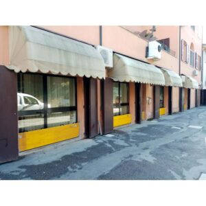 Facciata di edificio con tende da sole e barriere di protezione dalle inondazioni.