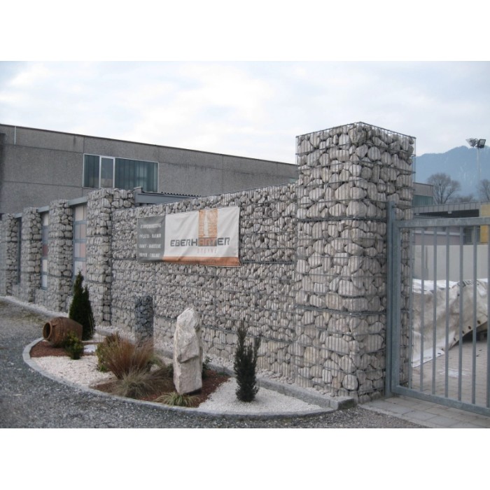 Muro di gabbioni con ciottoli e granulati come schermo per la privacy ed elemento da giardino.