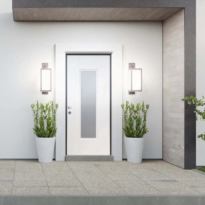 Porta blindata bianca con inserto in vetro, affiancata da luci esterne e piante in vasi bianchi.