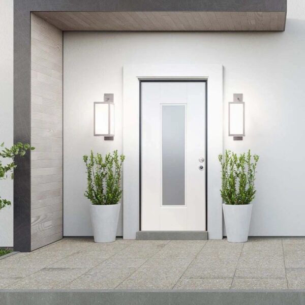 Porta blindata bianca con inserto in vetro, affiancata da due luci esterne e piante in vasi bianchi.