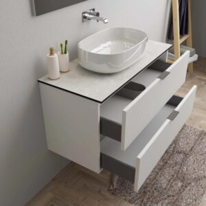 Mobile bagno bianco con lavabo d'appoggio e cassetti aperti. Arredo bagno.