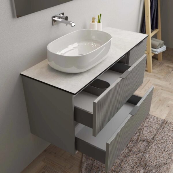 Mobile bagno grigio con lavabo d'appoggio e cassetti aperti. Arredo bagno.