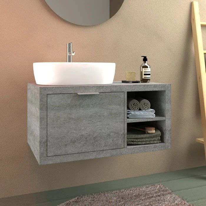 Mobile bagno grigio con lavabo da appoggio bianco e asciugamani nel vano a giorno.