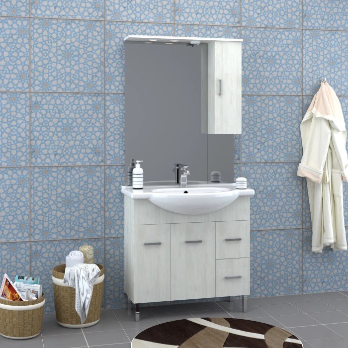 Set di mobili da bagno chiari con lavabo, mobile sottolavabo, specchiera e illuminazione.