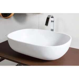 Lavabo d'appoggio bianco t.b.t. con rubinetto su ripiano marrone.